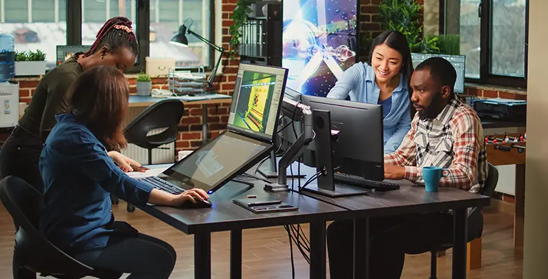 Game developers co-developing a project through connected workstations 